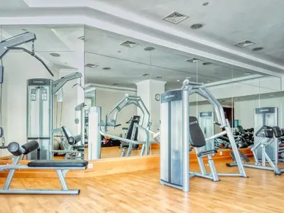 a gym with several tread machines and a mirror at Beachy Getaway in JBR with Private Beach Access in Dubai