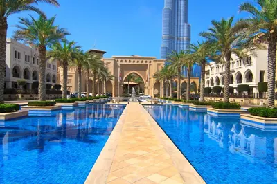 a pool in the middle of a building with palm trees at Stylish Downtown Retreat, Burj Crown, Opera & Boulevard View in Dubai