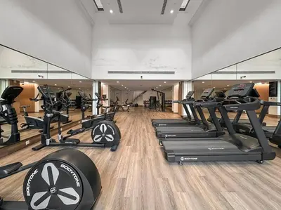 a gym with rows of treadmills and elliptical machines at FIRST CLASS 3BR Lively Sanctuary in Dubai