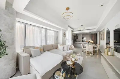 a living room with a white couch and a table at FIRST CLASS 3BR Lively Sanctuary in Dubai