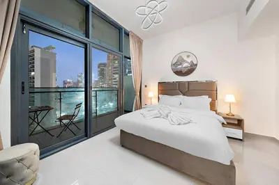 a bedroom with a bed and a large window at 1BR Dubai, Merano Canal View Retreat Near Metro Dining Shopping Mall in Dubai