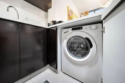 a washer and dryer in a kitchen with a sink at 1BR Dubai, Merano Canal View Retreat Near Metro Dining Shopping Mall in Dubai