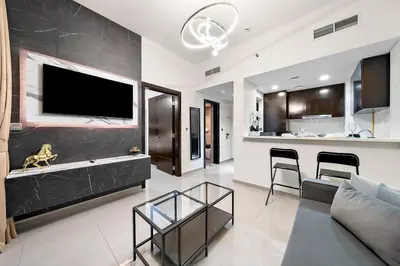 a living room with a couch and a tv on a wall at 1BR Dubai, Merano Canal View Retreat Near Metro Dining Shopping Mall in Dubai