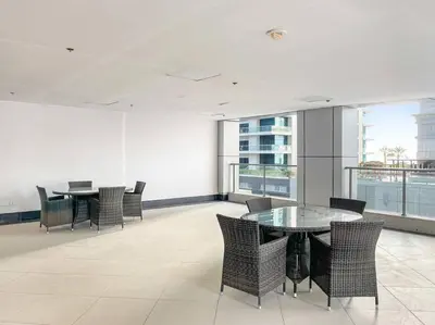 a dining room with tables and chairs and windows at Luxury 2BRin Torch Tower with Dubai Marina Skyline Views in Dubai