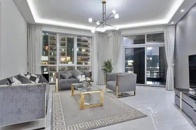 a living room with a couch and a table and a tv at Luxury 2BRin Torch Tower with Dubai Marina Skyline Views in Dubai