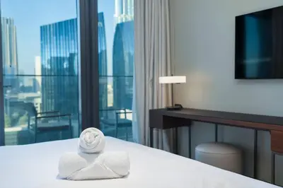 a hotel room with a bed with towels on it at Family 3BR Flat Free Parking, Gym, Pool & Burj Views in Dubai
