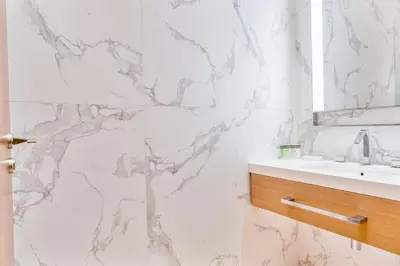 a bathroom with a sink and a marble wall at Family 3BR Flat Free Parking, Gym, Pool & Burj Views in Dubai