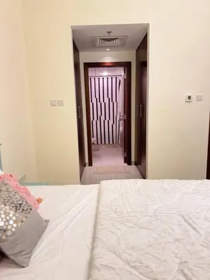a bedroom with a bed and a hallway with a door at 1 BHK Apartment in Dubai in front of Burj Khalifa in Dubai