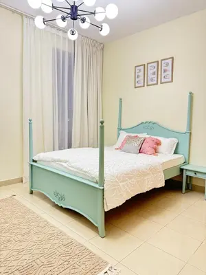 a bedroom with a bed with pink pillows and a chandelier at 1 BHK Apartment in Dubai in front of Burj Khalifa in Dubai