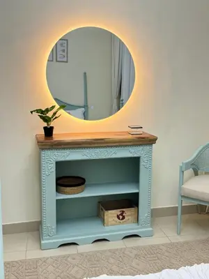 a mirror on top of a blue console table at 1 BHK Apartment in Dubai in front of Burj Khalifa in Dubai