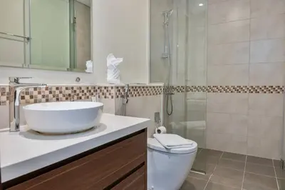 a bathroom with a sink and a shower and a toilet at FIRST CLASS 2BR Luxury Urban Escape in Dubai