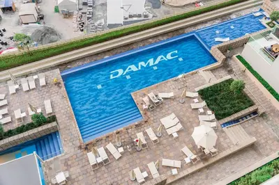 an overhead view of a swimming pool with tables and chairs at FIRST CLASS 2BR Luxury Urban Escape in Dubai