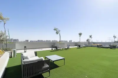 a large lawn with chairs and tables on a roof at GuestReady - Family retreat at Sobha Creek Vista in Dubai