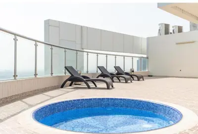 a pool on the roof of a building with chairs at Stunning Apartment - High Floor - Canal View in Dubai