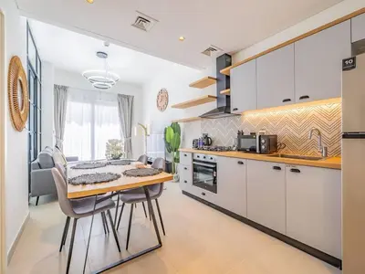 a kitchen with a table and chairs in a kitchen at Dubai Hills estate - 1Bedroom Apt in Dubai