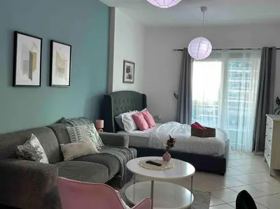 a living room with a couch and a table at Beautiful Studio Apartment in Dubai