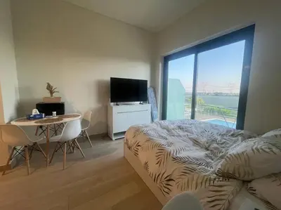a bedroom with a bed and a table and a television at The Perfect Couples Nest in Dubai