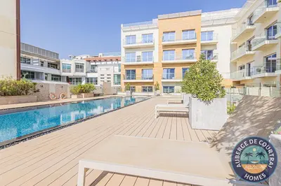 a swimming pool with a bench in front of a building at Cozy Modern Studio Oxford Residence in Dubai