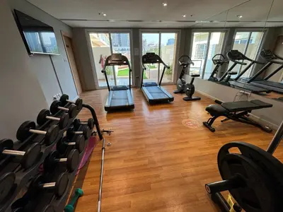 a gym with treadmills and exercise equipment in a building at Cozy Modern Studio Oxford Residence in Dubai