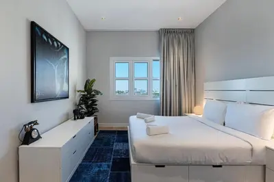 a bedroom with a large white bed and a window at Al Andalus Tower F, Cadiz JGE - 3BR Apartment - Allsopp & Allsopp in Dubai