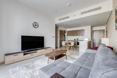 a living room with a couch and a large television at Knokey Luxury 1BR Apartments - 5 min walk to Burj Khalifa & Dubai Mall & Dubai Fountain in Dubai