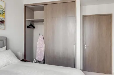 a bedroom with a sliding closet door and a bed at Knokey Luxury 1BR Apartments - 5 min walk to Burj Khalifa & Dubai Mall & Dubai Fountain in Dubai