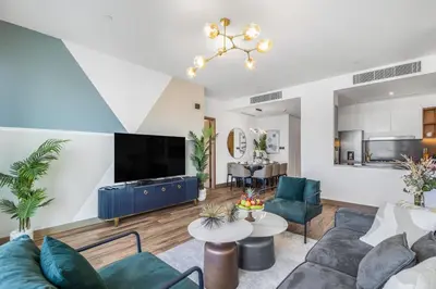 a living room with a couch and a tv at EDEN'S Homes & Villas - VIDA Dubai Marina Residences in Dubai