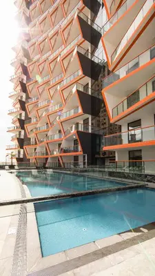 a building with a swimming pool in front of a building at Comfy 1br In Al Jaddaf Balcony Parking in Dubai