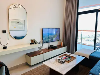 a living room with a tv and a table at Comfy 1br In Al Jaddaf Balcony Parking in Dubai