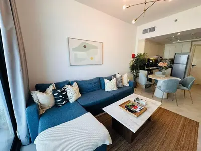 a living room with a blue couch and a table at Comfy 1br In Al Jaddaf Balcony Parking in Dubai