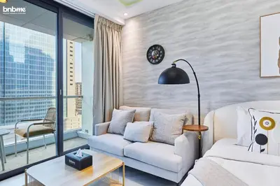 a living room with a couch and a table at bnbme - Stylish JLT Studio Near Metro Rooftop Pool Gym Balcony Marina Access in Dubai