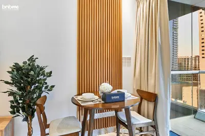 a dining room with a table and chairs and a window at bnbme - Stylish JLT Studio Near Metro Rooftop Pool Gym Balcony Marina Access in Dubai