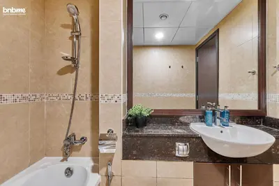 a bathroom with a sink and a bath tub at bnbme - Stylish JLT Studio Near Metro Rooftop Pool Gym Balcony Marina Access in Dubai