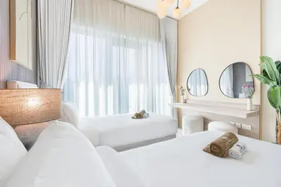 a white room with two beds and a table at Nicely Furnished Home in the Heart of Business Bay in Dubai