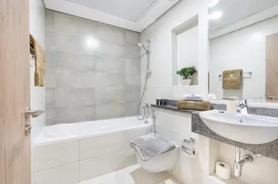 a bathroom with a sink and a tub and a toilet at Nicely Furnished Home in the Heart of Business Bay in Dubai