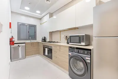 a kitchen with a washing machine and a microwave at Nicely Furnished Home in the Heart of Business Bay in Dubai