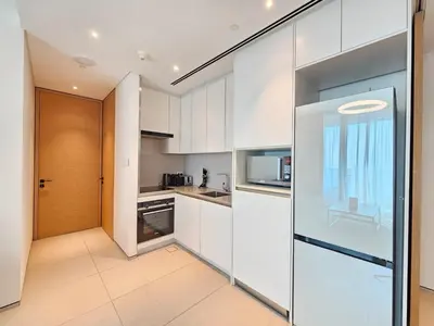 a kitchen with white cabinets and a sliding glass door at Stylish 1BR apartment in Address Beach Residence in Dubai
