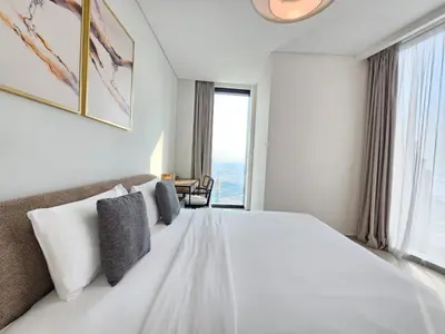 a bedroom with a large white bed with a large window at Stylish 1BR apartment in Address Beach Residence in Dubai
