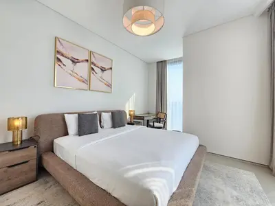 a bedroom with a large white bed and a couch at Stylish 1BR apartment in Address Beach Residence in Dubai