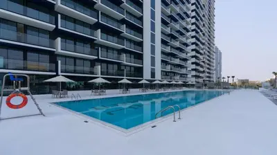 an empty swimming pool in front of a building at Sleek 1br In Jvc Free Parking Pool & Balcony in Dubai
