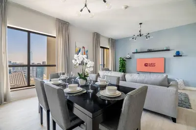 a dining room with a table and a couch at GuestReady - Beachfront delight in JBR in Dubai