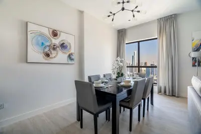 a dining room with a black table and chairs at GuestReady - Beachfront delight in JBR in Dubai