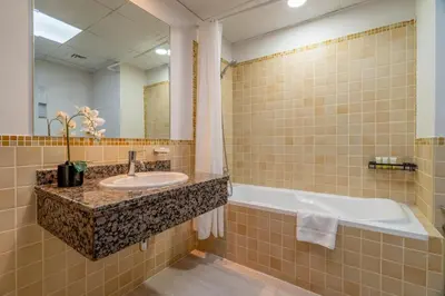 a bathroom with a sink and a bath tub at GuestReady - Beachfront delight in JBR in Dubai