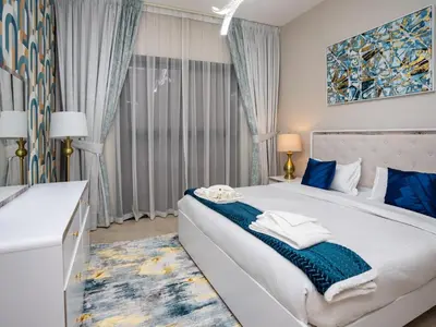 a bedroom with a large bed with blue accents at Elgant 2 bedroom in Dubai