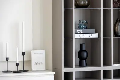 a room with a shelf with a vase and candles at Luxury Coastal Escape - Bright 3BR Apt - La Vie JBR in Dubai