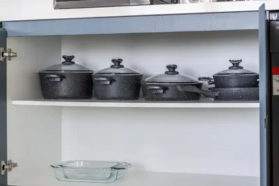 a group of pots on a shelf in a kitchen at Luxury Coastal Escape - Bright 3BR Apt - La Vie JBR in Dubai