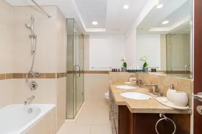 a bathroom with three sinks and a shower at Lux BnB I 29 Blvd I Burj Khalifa & Fountain Views in Dubai