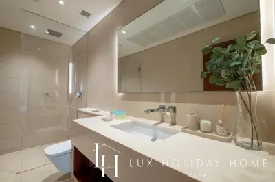 a bathroom with a sink and a toilet and a mirror at LUX The Marina Gate Sea View Suite 2 in Dubai