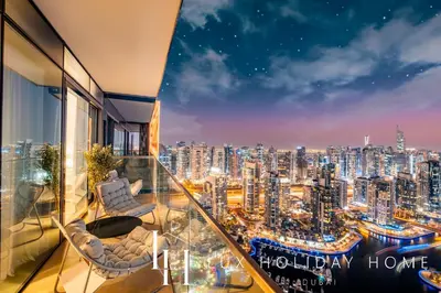 a view of a city at night from a balcony at LUX The Marina Gate Sea View Suite 2 in Dubai