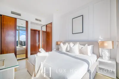 a white bedroom with a large bed and a desk at LUX The Marina Gate Sea View Suite 2 in Dubai